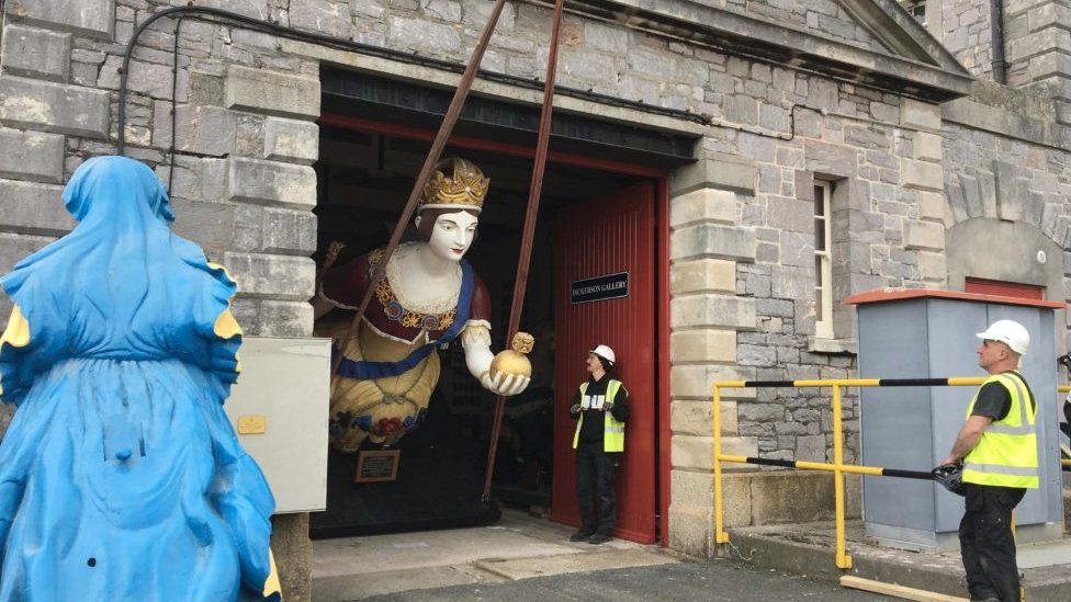 Figurehead of a queen leaving a workshop