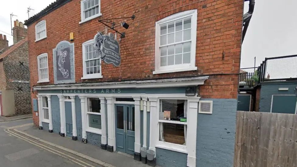 The front of the Carpenters Arms. A grey-fronted, brick-built pub. 