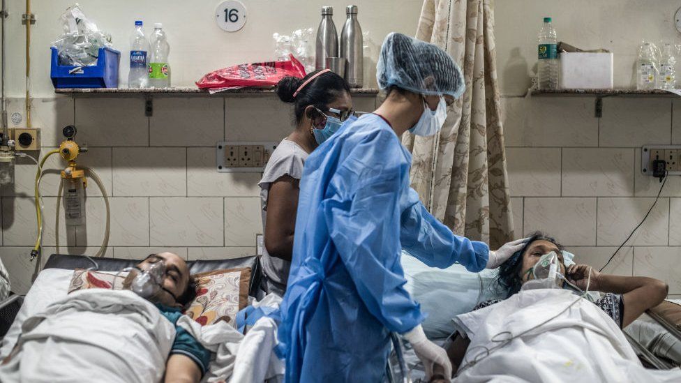Медицинский персонал обслуживает пациента, заразившегося коронавирусом, в отделении неотложной помощи больницы Covid-19 3 мая 2021 года в Нью-Дели, Индия.