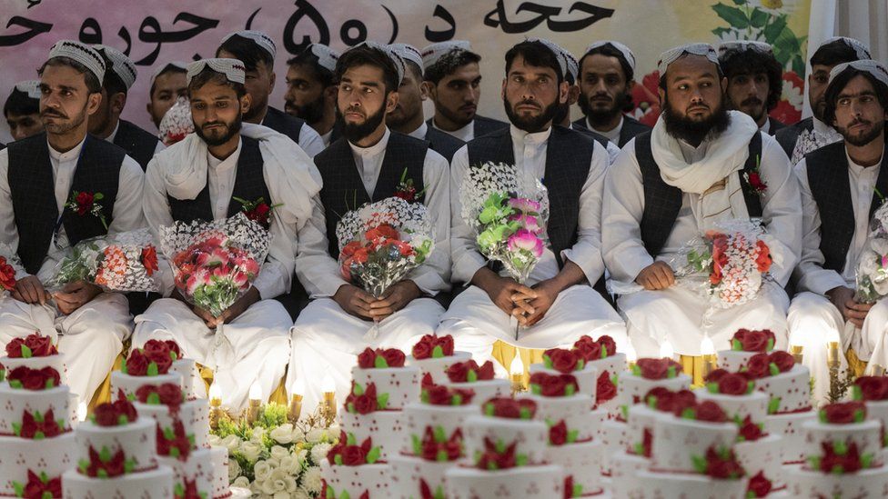 Grooms hold bouquets of flowers during a ceremony in Kabul