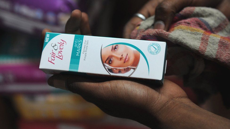 Woman holding a 'Fair & Lovely' brand product