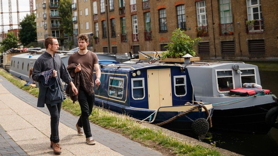 Two men walk by a canal in East London