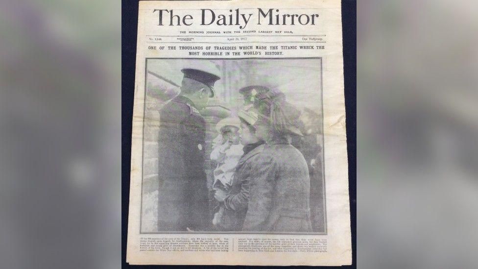 The front of an old Daily Mirror newspaper. It has a large black and white photo of two women looking worried, one holding a baby. The headline reads "One of the thousands of tragedies which made the Titanic wreck the most horrible in the world's history".