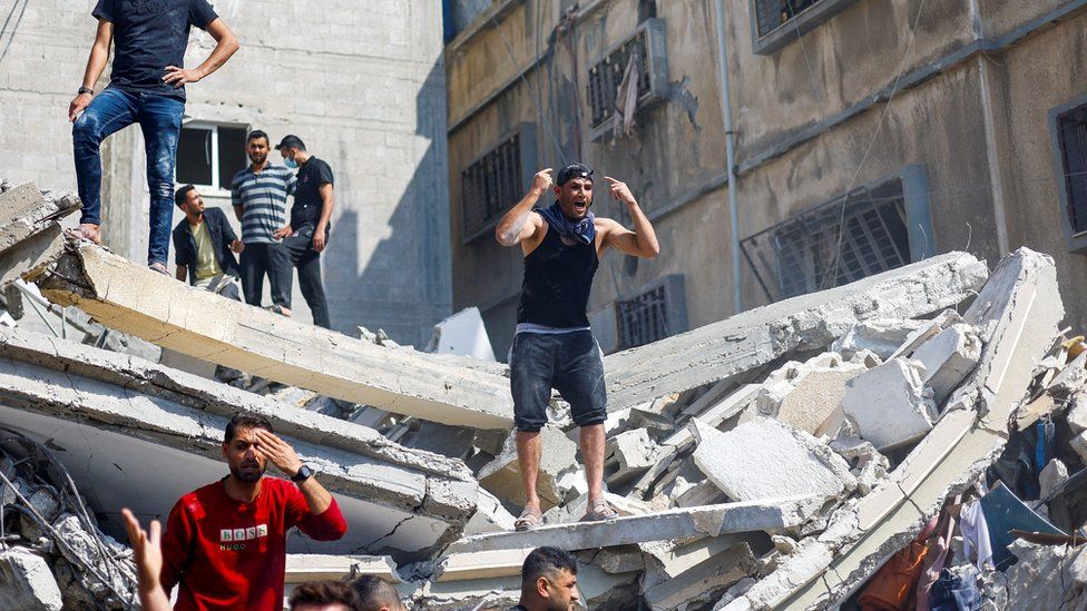 Palestinians search for casualties at the scene of an Israeli strike in Khan Younis, in the southern Gaza Strip (24 October 2023)