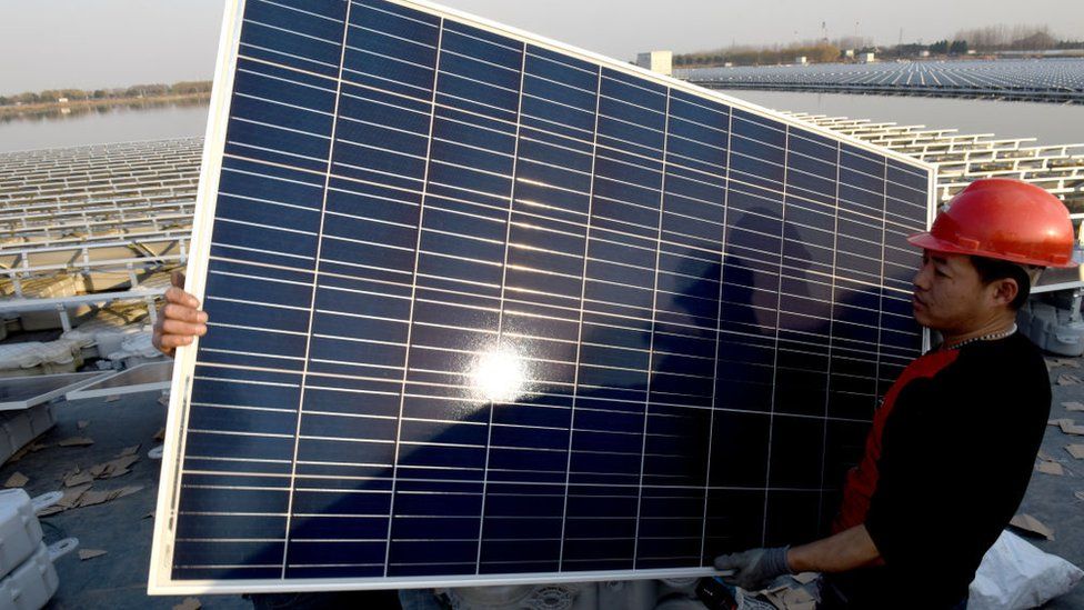 Trabajadores chinos instalan un panel solar en una planta fotovoltáica en la provincia de Huainan
