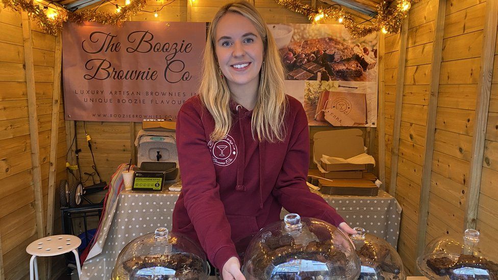 Emily showcasing her homemade brownies in her stall at the market