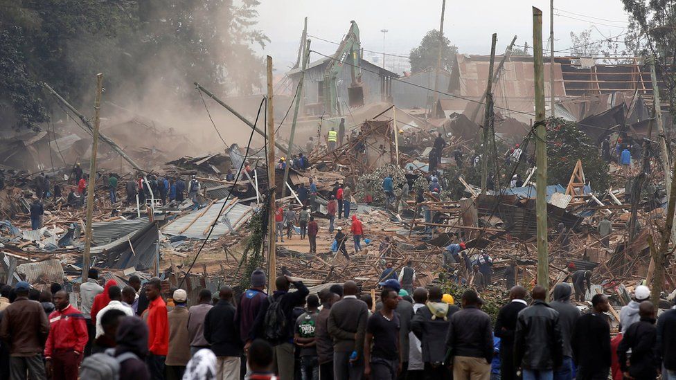 Onlookers watch as bulldozers demolish houses to make way for a new road in the Kibera slum in Nairobi, Kenya, July 23, 2018.
