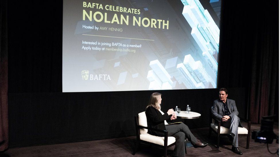 Amy Hennig interviews Nolan North on stage before he accepts his BAFTA