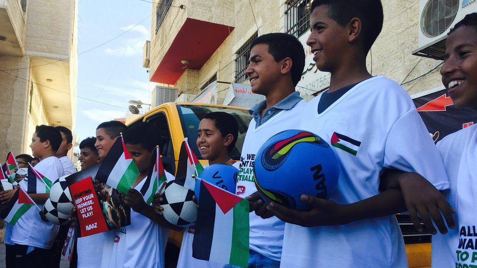 Palestinian boys dressed in football kit and carrying balls (12 October 2016)