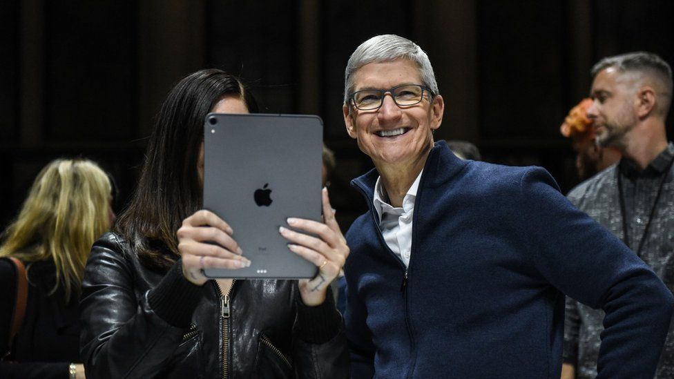 Tim Cook, CEO of Apple laughs while Lana Del Rey (with iPad) takes a photo during a launch event at the Brooklyn Academy of Music on October 30, 2018 in New York City. Apple debuted a new MacBook Pro, Mac Mini and iPad Pro.