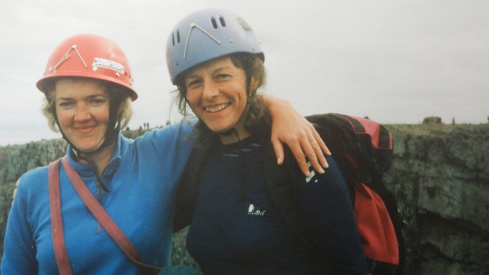 Two women in hard hats and mountain climbing gear