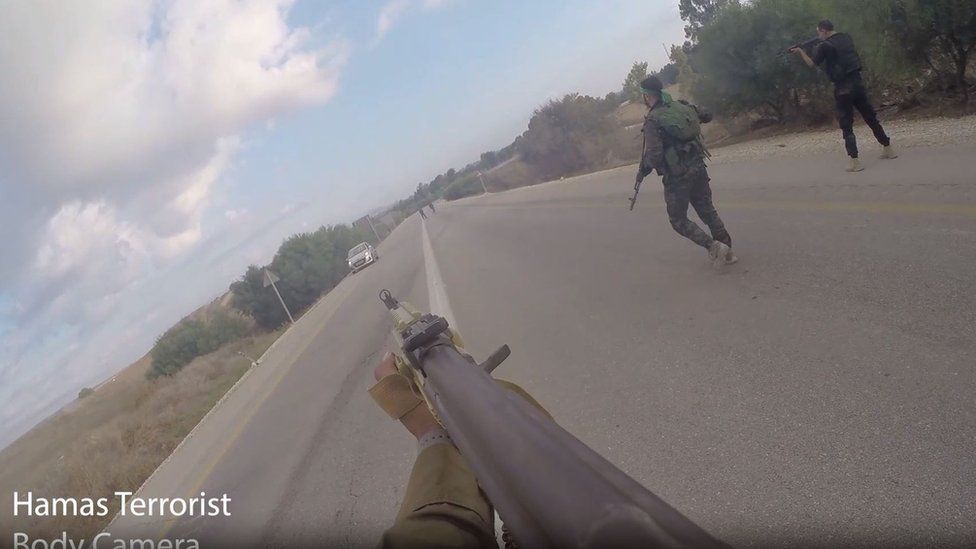 Кадр из видео, на котором боевики ХАМАС направляют пистолет на машину на дороге