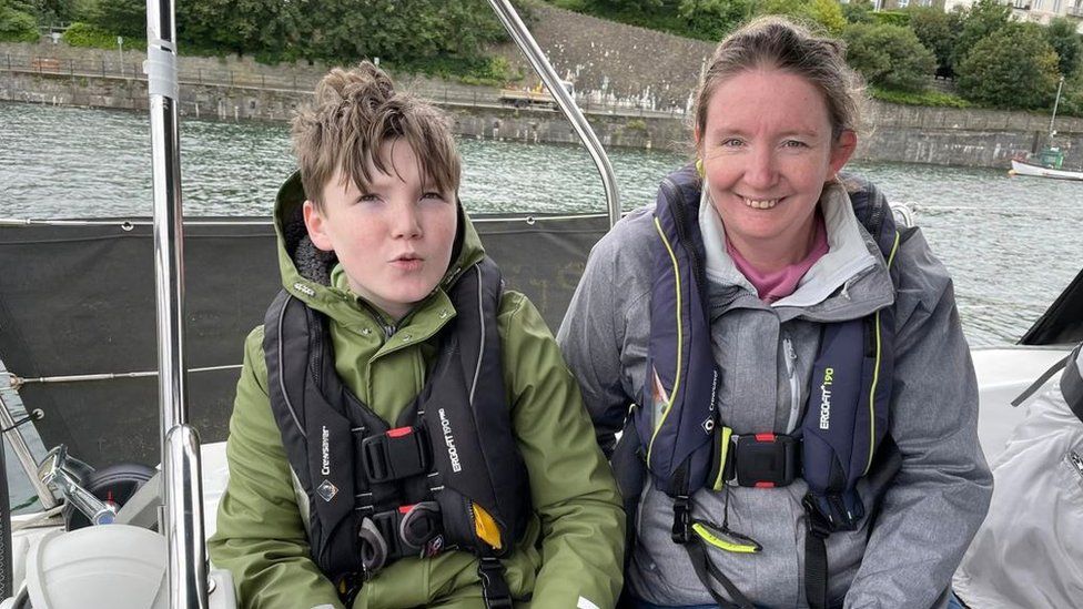 An adult and child from the charity on a boat