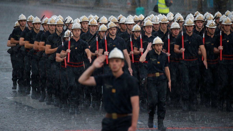 French firefighters "Pompiers de Paris", walk under heavy rain on the Champs Elysees during a rehearsal of the traditional Bastille Day military parade in Paris, France, July 10, 2017