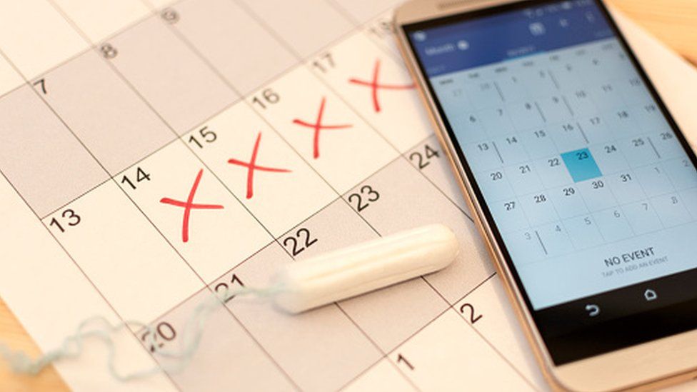 A tampon and a period tracker on a calendar