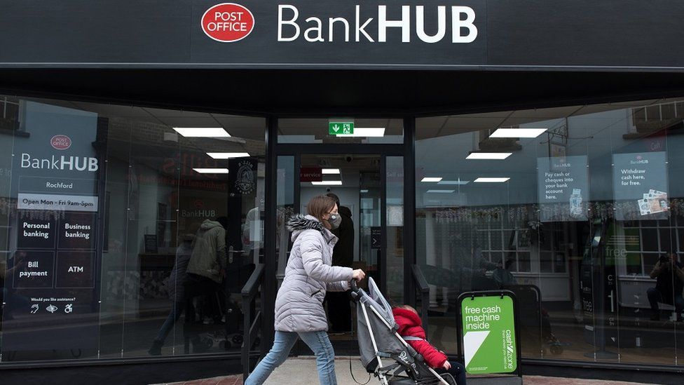 Женщина толкает коляску мимо нового банковского центра 7 апреля 2021 года в Рочфорде, Англия.