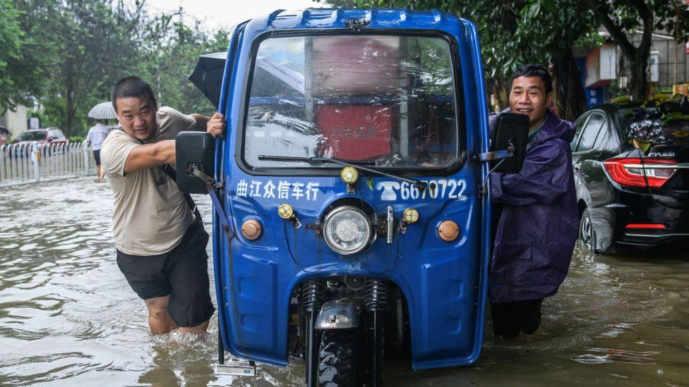 Citizens push their car forward in the waterlogged road on June 21, 2022 in Shaoguan, Guangdong Province of China.