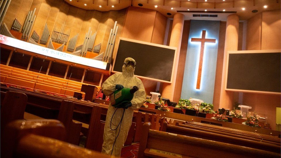 Worker disinfecting a church