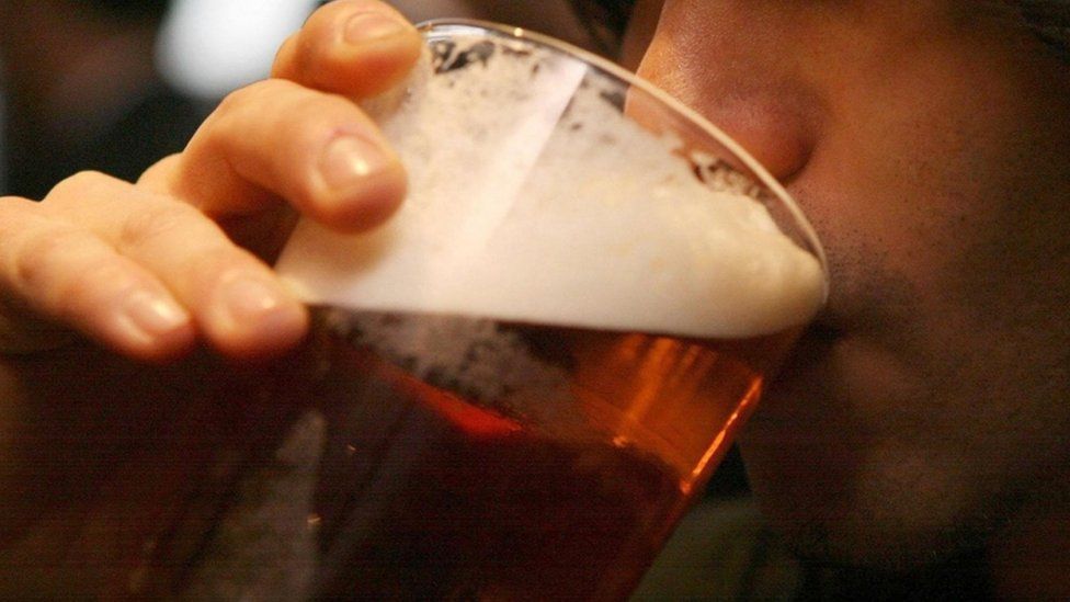 A man drinking a pint of beer