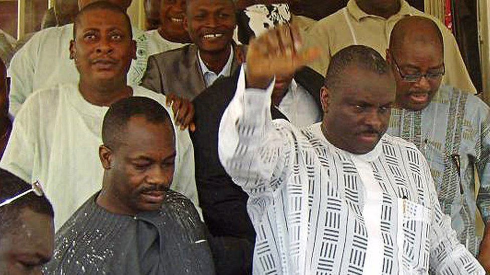 Former governor of oil-rich Delta State James Ibori (R) raises his hand to acknowledge his supporters after leaving the courtroom at an Asaba High Court on December 17, 2009