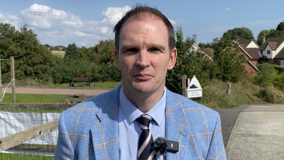 Dan Poulter MP wearing a blue striped suit and tie