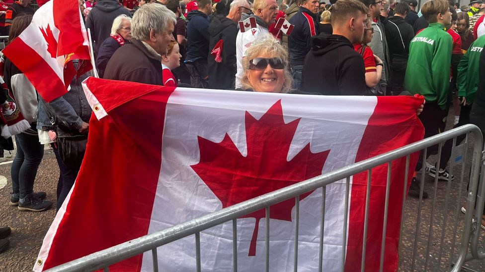 A woman carrying a Canada flag