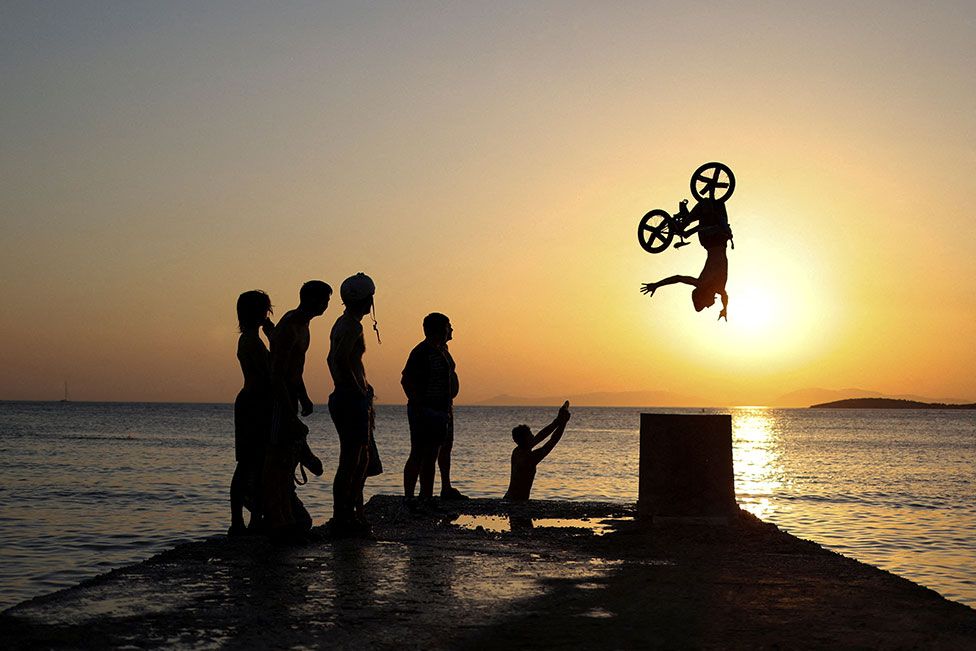 A biker performs tricks at Kavouri beach during a heatwave near Athens, Greece, on 24 July 2022