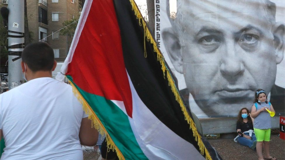 Demonstrator carries a Palestinian flag at a protest in Tel Aviv against Israel's annexation plans (06/06/20)