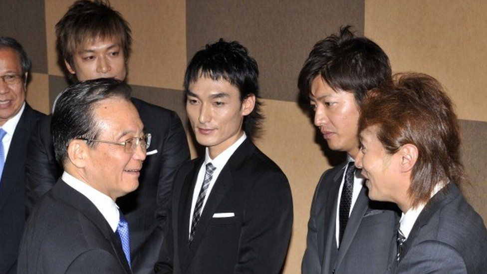 Visiting Chinese Prime Minister Wen Jiabao (L) shakes hands with Japanese pop group SMAP