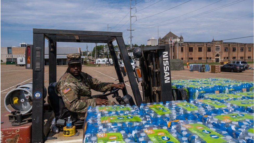 National guard troop with water on a forklift