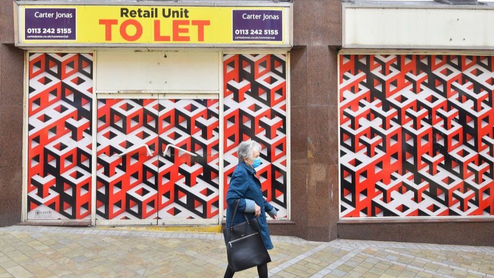 Woman walks past closed store