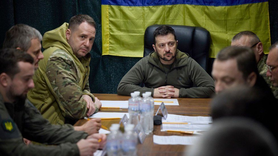 A handout photo made available by the Ukrainian presidential press service shows Ukrainian President Volodymyr Zelensky (C) meets with military authorities during visit the recaptured city of Kherson