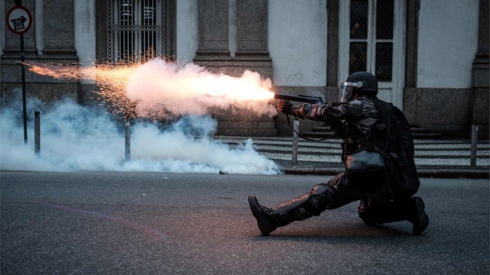 Military policeman fires at demonstrators in Rio de Janeiro.