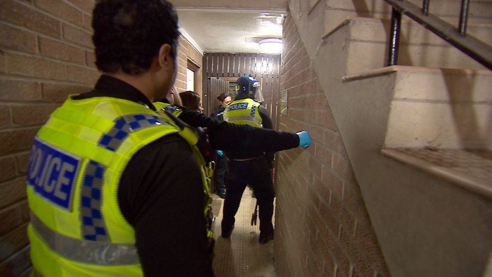 Police raid of a property with officers in a stairwell