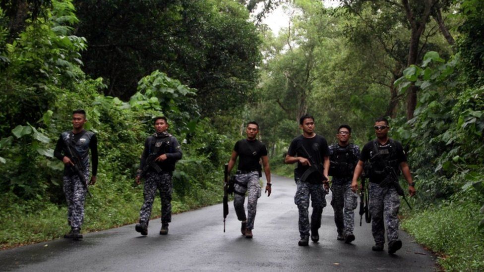 Prison personnel patrol during a manhunt for more than 150 inmates who escaped after gunmen stormed a prison in North Cotabato province, southern Philippines