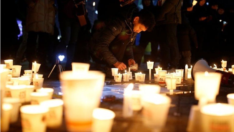 A man places a candlelight during a protest demanding President Park Geun-hye"s resignation in Seoul, South Korea, on 31 December