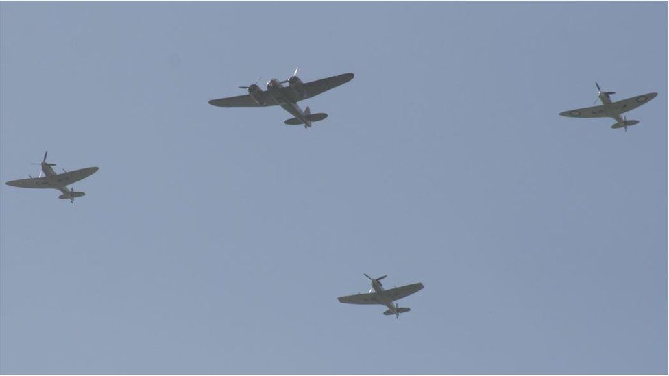 Four planes flying in a hazy blue sky