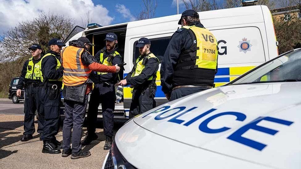 Police officers arrest a climate change protestor in Thurrock on 2 April 2022