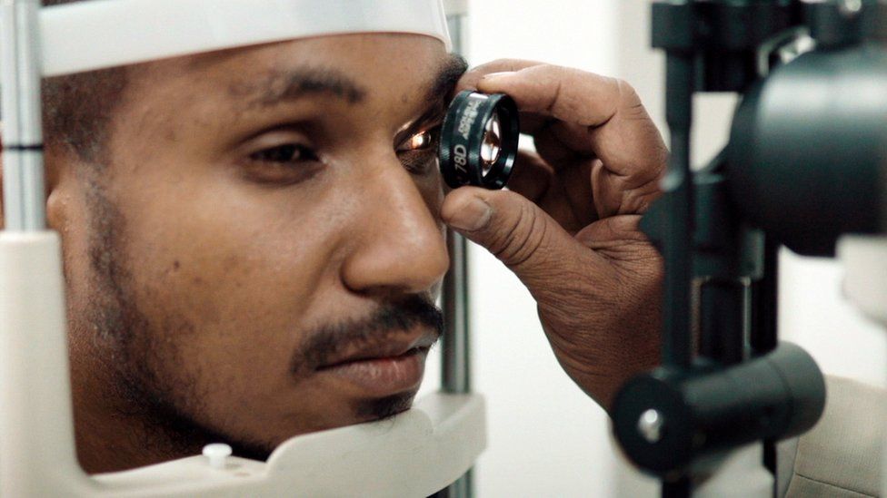 A antheral   with retinitis pigmentosa having his eyes examined