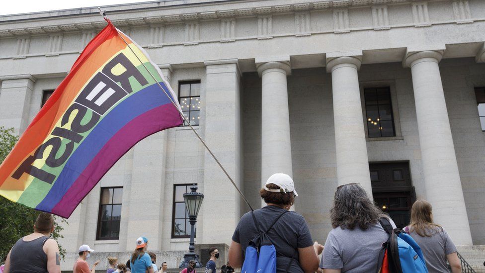 A protester holding a flag that reads resist during the demonstration. Transgender rights advocates stood outside of the Ohio Statehouse at noon to oppose and bring attention to an amendment to a bill that would ban transgender women from participating in high school and college women sports