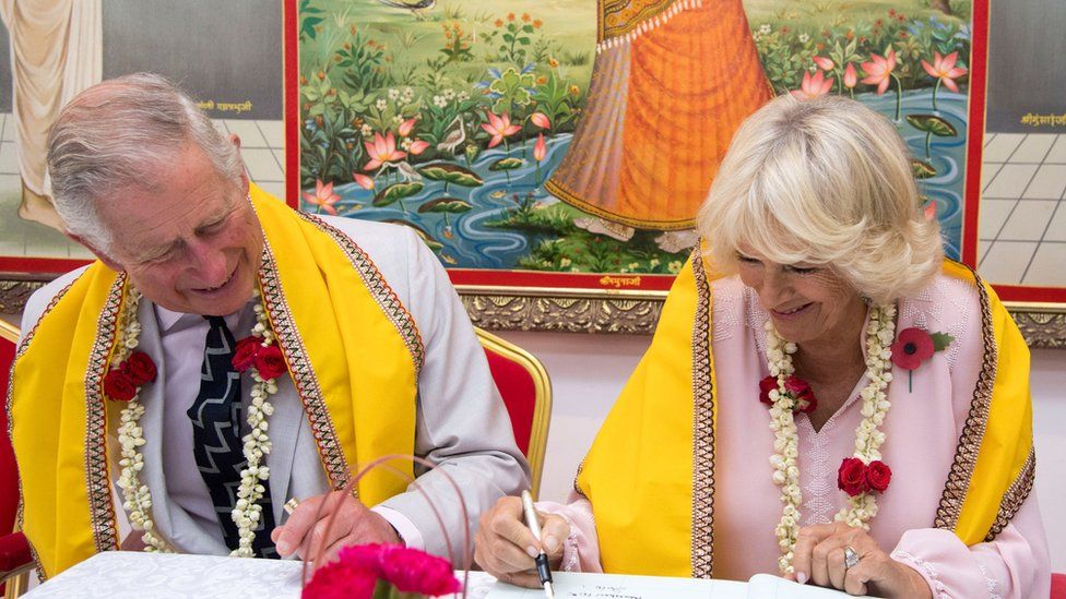 Charles and Camilla sign the visitors' book at a Hindu temple in Bahrain