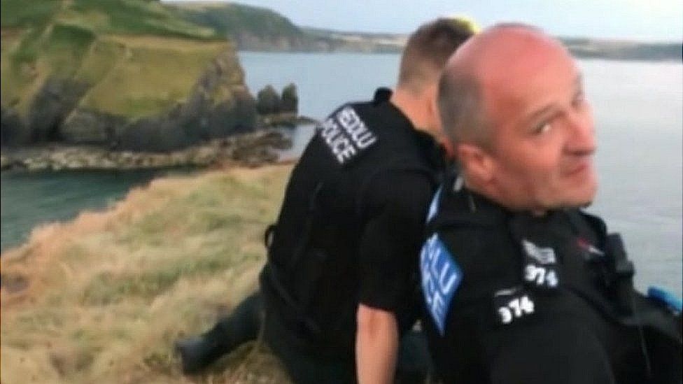 Two police officers stuck on a cliff