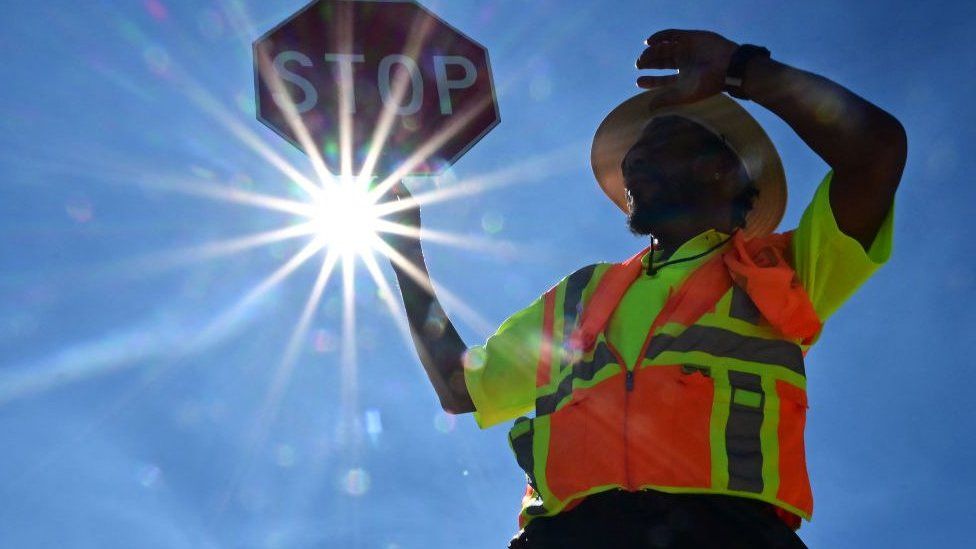 Traffic warden Rai Rogers mans his street corner during an 8-hour shift under the hot sun in Las Vegas, Nevada on July 12, 2023, where temperatures reached 106 degrees amid an ongoing heatwave.