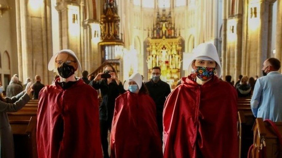 Protesters walk through a cathedral in Lodz, Poland