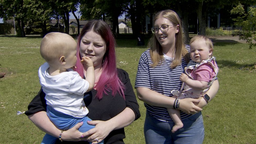 Laura Magee and Rachel Smyth hold their babies in a park