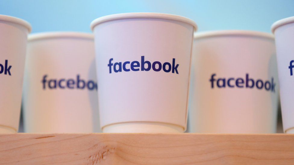 The Facebook logo on coffee cups