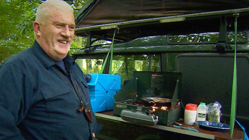 Michael Sanderson cooks food from a hob attached to the side of his car