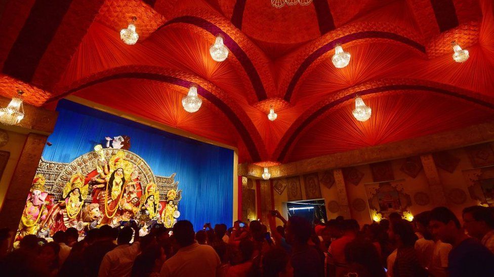 ผู้ศรัทธารวมตัวกันเพื่อสวดมนต์ต่อเทวรูปของเทพธิดาฮินดู Durga ระหว่างเทศกาล 