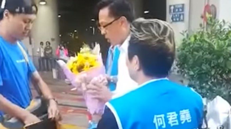 The moment before Mr Ho (right, white shirt) was attacked by the man in the blue shirt