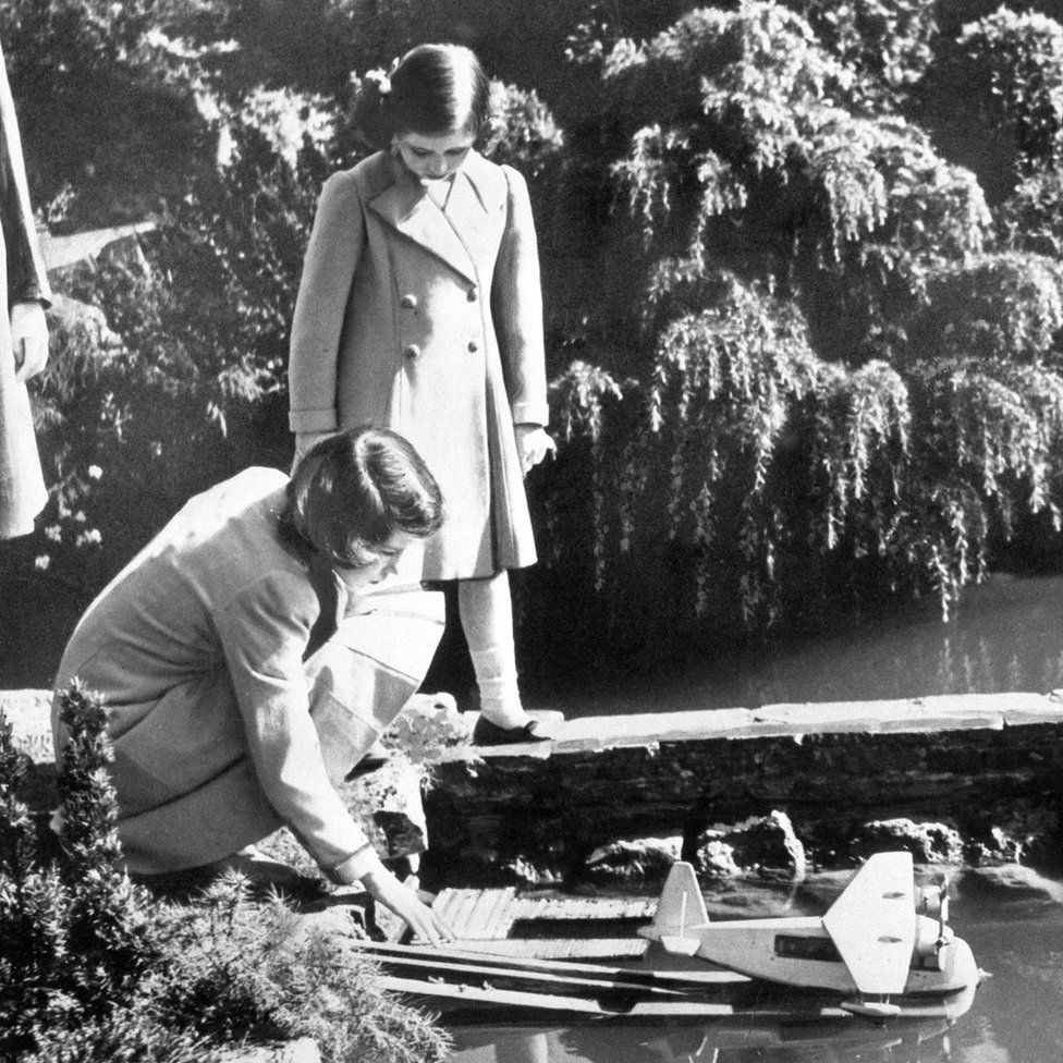 Принцессы Елизавета и Маргарет запускают модель гидросамолета в модельной деревне Беконскот в Биконсфилде, Бакингемшир